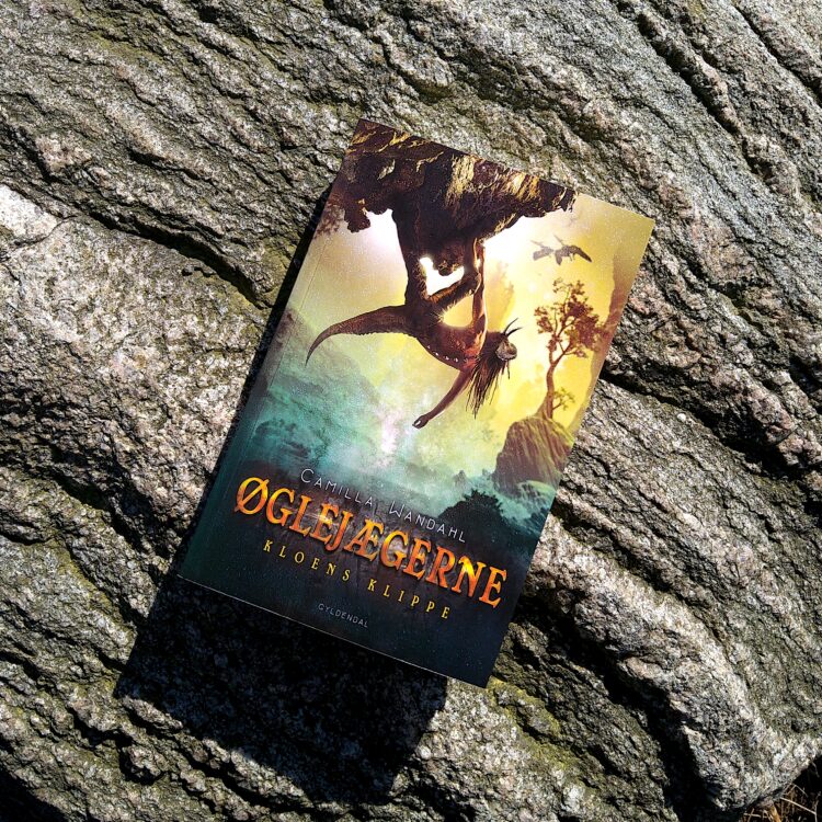 Bogen Øglejægerne Kloens Klippe ligger på en baggrund af klippe sten i solskin