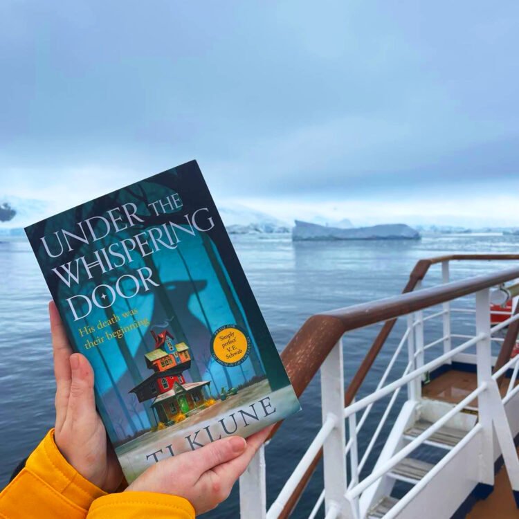 Bogen Under the Whispering Door holdes op foran udsigten til isbjerge i Antarktis